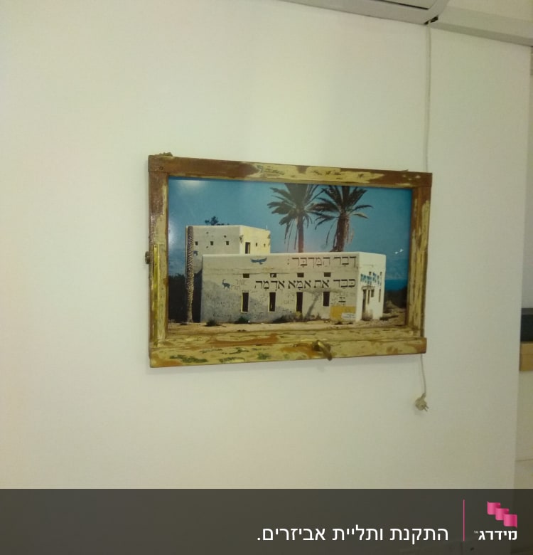 תמונה תלויה על קיר עם מסגרת עץ